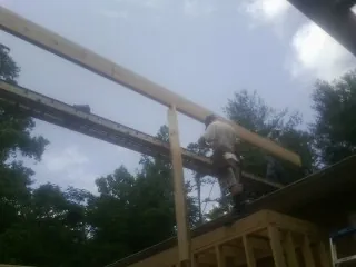 Carpenter setting a ridge beam over a new addition frame — Ice Dam Removal by Roofing Brothers in Eau Claire